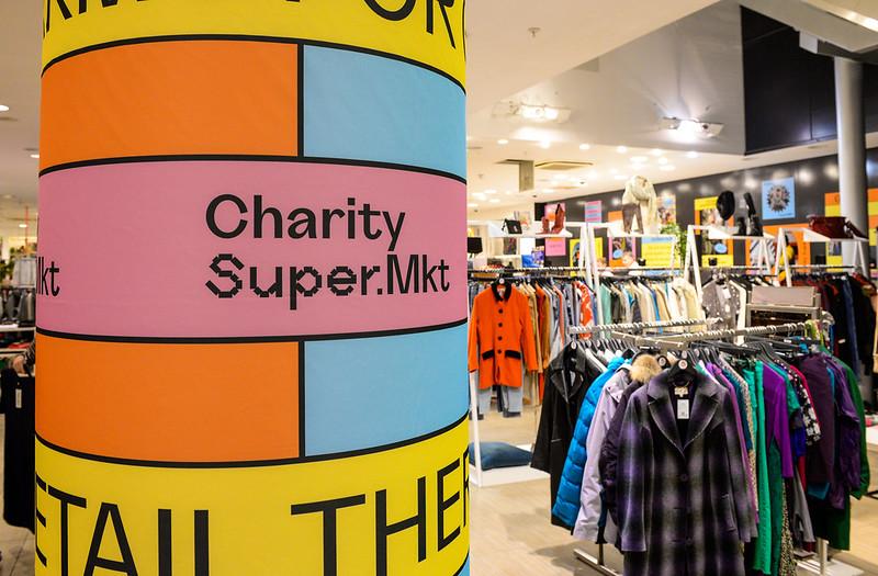 Colourful graphics on a pillar next to a clothing rail