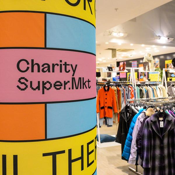 Colourful graphics on a pillar next to a clothing rail