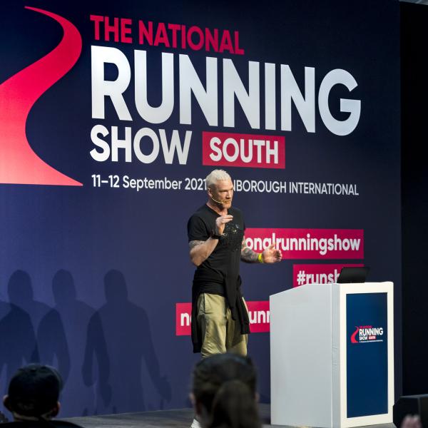 The Running Show Event Graphics behind a man