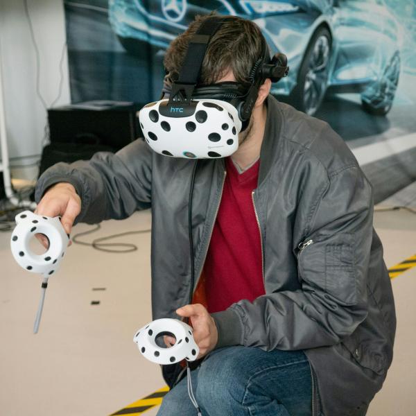 Person wearing augmented reality goggles and controllers.